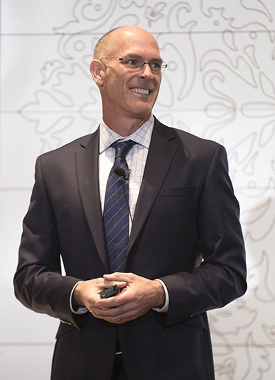 Keynote speaker discussing leadership and coaching at a corporate event.